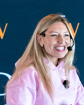 Ewa Wardęga, smiling, in a pink sweatshirt