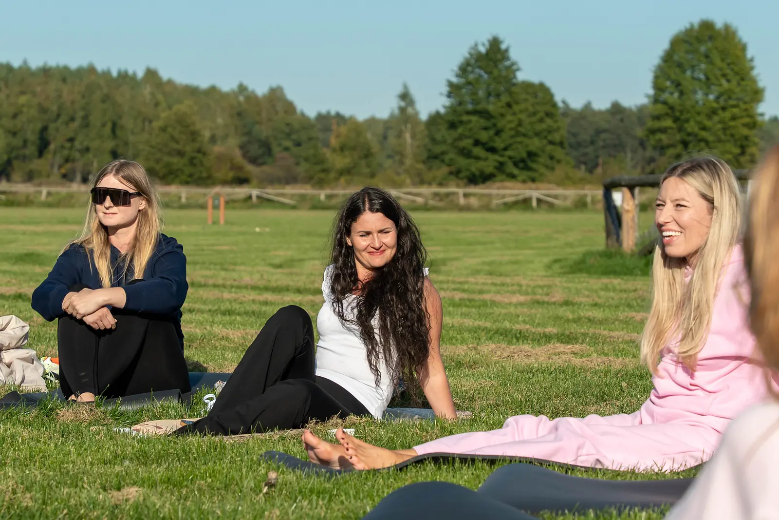 Ewa Wardęga laughs in a circle of participants in a meadow