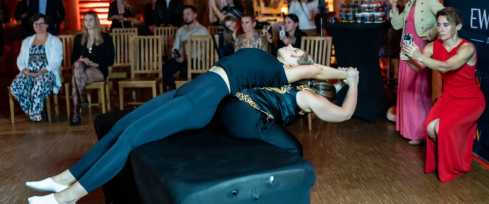 An evening duo massage demonstration, guests watching from chairs
