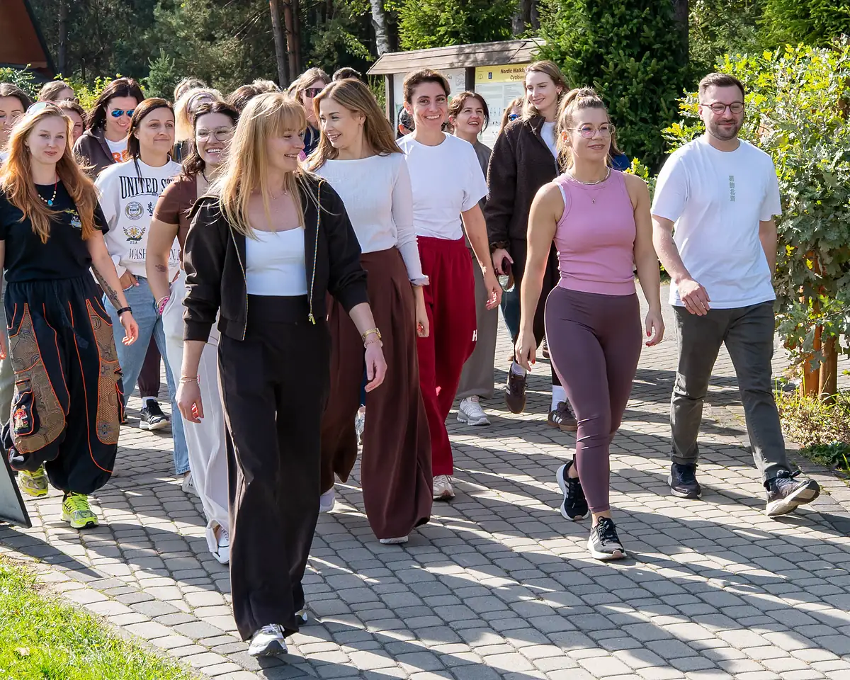 Camp participants walk together along a tree-lined path